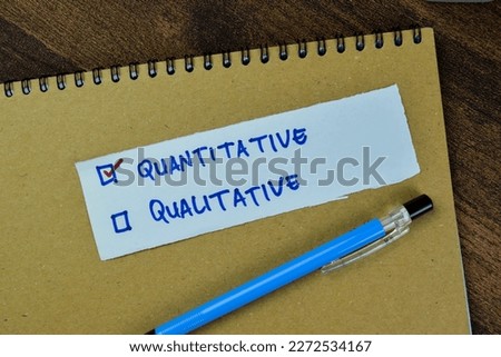 Concept of Quantitative and Qualitative write on sticky notes isolated on Wooden Table.