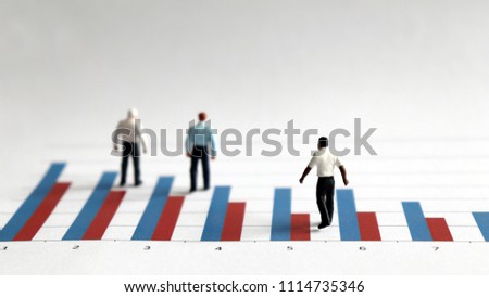 The concept of racial discrimination in employment and promotion. The miniature men standing on a bar graph.