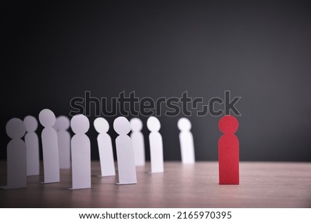 Concept of racial exclusion with cutouts of people of one color grouped discriminating against another person of another color. Front view