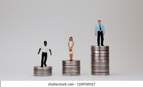 The Concept Of Racial Income Gap. Miniature people standing on pile of coins.