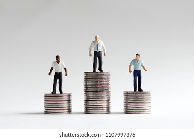 The Concept Of Racism In A Company. Miniature People Standing On A Pile Of Coins.