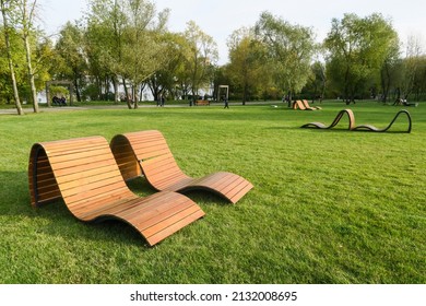 The Concept Of Recreation In A City Park. Sun Loungers And Benches On The Lawn With A Neatly Trimmed Lawn Without People. Panorama Of A Well-groomed Lawn With Beautiful Stripes After Mowing.          