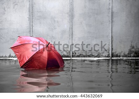 Concept of red umbrella floating on flooded street and waiting for help me after the rain.