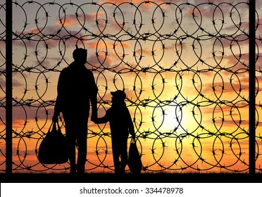 Concept Of Refugee. Silhouette Of A Family With A Child Refugee Father Near The Fence With Barbed Wire At Sunset