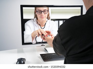 Concept Of Remote Medical Examinations. A Doctor Makes A Remote Examination On A Patient's Home Through The Monitor