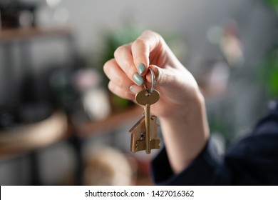 Concept Of Renting An Apartment. House Key In Womans Hands. Young Woman. Modern Light Lobby Interior. Real Estate, Hypothec, Moving Home Or Renting Property.