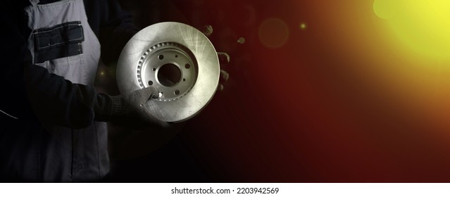 concept of replacing car brake discs. Brake disc in the hands of a master on a dark background, repair of the brake system - Shutterstock ID 2203942569