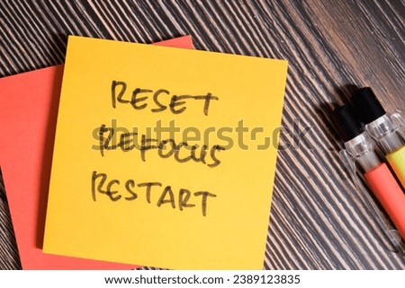 Concept of Reset, Refocus, Restart write on sticky notes isolated on Wooden Table.