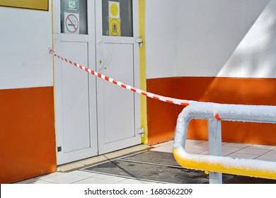 Concept For Restricted Area On Virus Coronavirus Global Outbreak And Quarantine. Closed Entrance Door To An Office Or Institution Fenced With Red And White Striped Barrier Ribbon For No Entry At Build