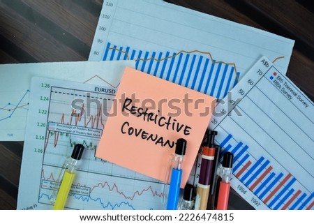 Concept of Restrictive Covenant write on sticky notes isolated on Wooden Table.