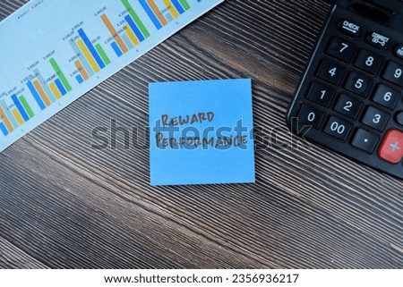 Concept of Reward Performance write on sticky notes isolated on Wooden Table.