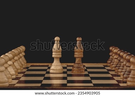 Concept of rivalry between teams and leaders. Two bishops, each with many pawns following, face off on the chessboard. Black background with copy space.