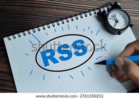 Concept of RSS - Reality Simple Syndication write on book isolated on Wooden Table. To publish frequently update works like blog entries