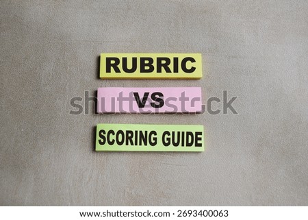 Concept of rubric vs scoring guide write on sticky notes isolated on Wooden Table.