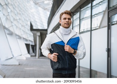 Concept of running in the city. Runner man warming up, training outdoor, making cardio exercise. Sportive man jogging on the street, keeps his body in good physical shape. Sport and healthy lifestyle - Shutterstock ID 2093095456