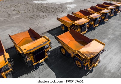 Concept Sale Of Industrial Equipment. Parking With Big Yellow Mining Truck For Coal Industry, Iron Ore And Gold. Aerial Top View.