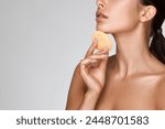 concept salon skin care face and body. beautiful young woman washes her face with sponge, clean smooth skin. Close-up portrait beauty girl without wrinkles. Isolated in background