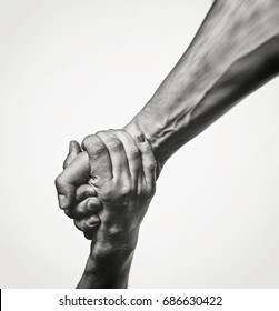 Concept of salvation. Black and white image of the hands of two people at the time of rescue (help). - Shutterstock ID 686630422
