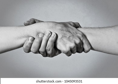 Concept Of Salvation. Image Of The Hands Of Two People At The Time Of Rescue (help). Black And White.