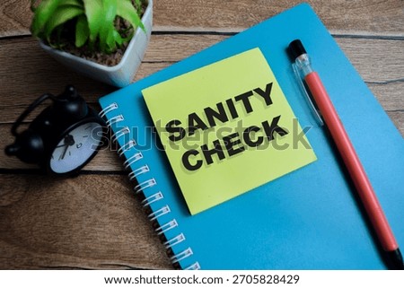 Concept of sanity check write on sticky notes isolated on Wooden Table.
