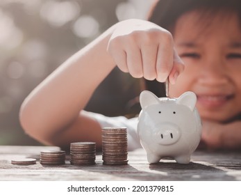 Concept Of Saving Money. Happy Asian Child Girl Save Money Putting Coin Into Piggy Bank, Coins Stack Growing. Concept Save Money, Cash, Education, Growth, Finance, Bank, Management, Income, Business