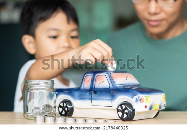Concept of savings and financial planning of car\
leasing. cute boy putting coins in a car piggy bank, Business,\
finance or budget plan money saving for buying a new car and auto\
insurance concept.