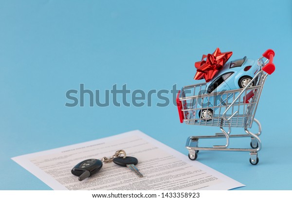 Concept of selling cars on blue background. Sell\
and buy car, car financing, car key for Vehicle Sales.  Buying car.\
Copy space