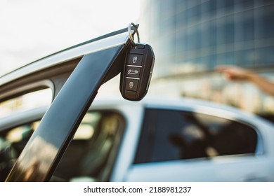 The concept of selling the purchase of leasing or renting a new car. Close-up of a car key hanging on the edge of an open vehicle door - Shutterstock ID 2188981237