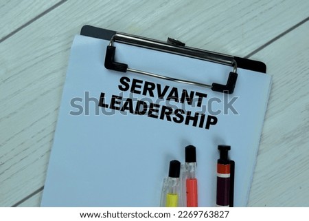 Concept of Servant Leadership write on paperwork isolated on Wooden Table.