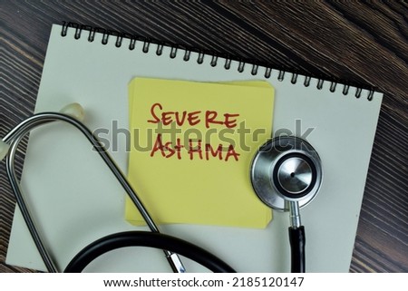 Concept of Severe Asthma write on sticky notes with stethoscope isolated on Wooden Table. Selective focus on severe asthma text