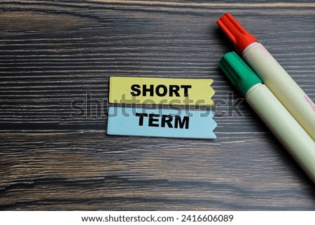 Concept of Short Term write on sticky notes isolated on Wooden Table.