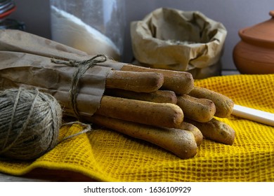 Concept Shot Of Spice Bread Sticks With A Wooden Spoon On The Wood Table, Oatmeal And A Skein Of Bag Thread. Front Views