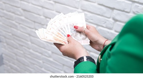 Concept showing the Croatian economy and finance. a woman wearing a green jacket is counting bills of Croatian kuna.