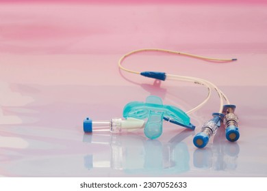 Concept of sick baby. Light blue dummy and triple lumen short-term central venous catheter with three infusion channels on pastel-colored background