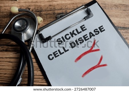 Concept of sickle cell disease write on clipboard isolated on Wooden Table.