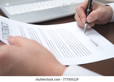 A concept of signing a contract holding a pen. Defocused. - Shutterstock ID 777505129