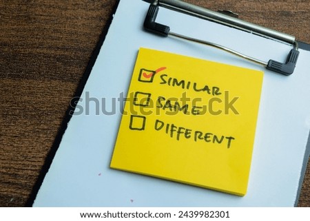 Concept of Similar, Same, Different write on sticky notes isolated on Wooden Table.