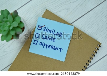 Concept of Similar write on sticky notes isolated on Wooden Table.