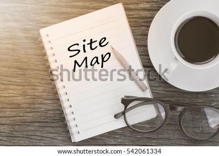 Concept Site map message on notebook with glasses, pencil and coffee cup on wooden table.