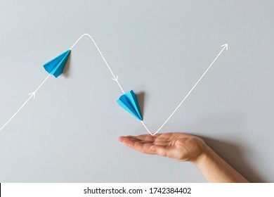 concept of small business support. graph of of economic crisis, stagnation and recovery with help of state. paper plane flies up, falls down. - Shutterstock ID 1742384402