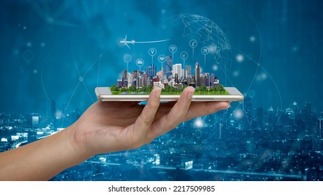 Concept Smart city and Internet of things (IOT), Smart city model on smartphone in woman's hand holding with Abstract Blue Technology Background and world map, Binary Computer Code. - Powered by Shutterstock