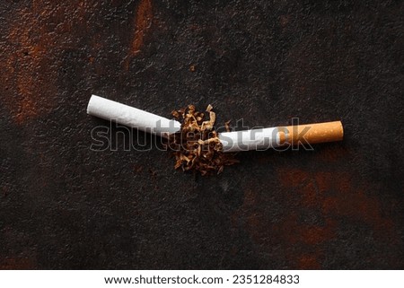 Concept of smoking addiction, broken cigarette, close-up.