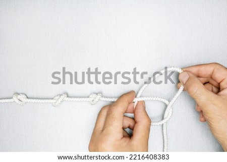 Concept of solution problems. male hands unties a knot of rope.  商業照片 © 