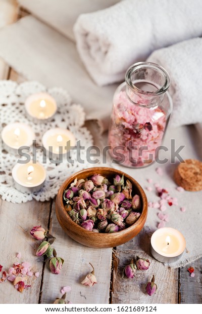 Concept of spa treatment with roses. Dry flowers in a\
bowl, herbal tea, towel, candles as decor. Atmosphere of relax and\
pleasure, comfort, anti-stress and detox procedure. Luxury\
lifestyle. 