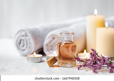 Concept of spa treatment in salon. Natural organic oil, towel, candles as decor. Atmosphere of relax, serenity and pleasure. Anti-stress and detox procedure. Luxury lifestyle. White wooden background - Powered by Shutterstock