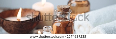 Concept of spa treatment in salon with pure organic natural oil. Atmosphere of relax, detention. Aromatherapy, candles, towel, wooden background. Skin care, body gentle treatment. Banner copy space