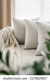 Concept of spending weekend in well furnished bedroom with plants. Selective focus on comfort couch with cushions in bright apartment with cozy living room. Scandinavian interior with white armchair - Shutterstock ID 2170829827