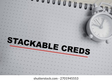 Concept of stackable creds write on book isolated on Wooden Table.