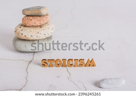 Concept of stoicism wooden letters on the background of a pyramid of stones on the table