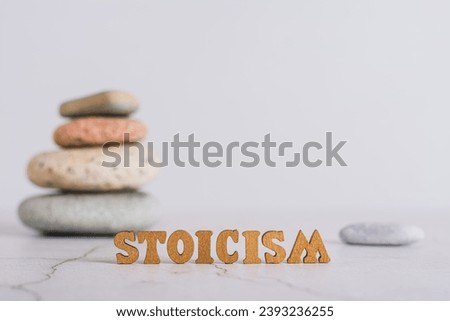Concept stoicism word made from letters and pyramid of stones on gray background